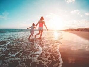 mother-daughter-walking-in-ocean-beach